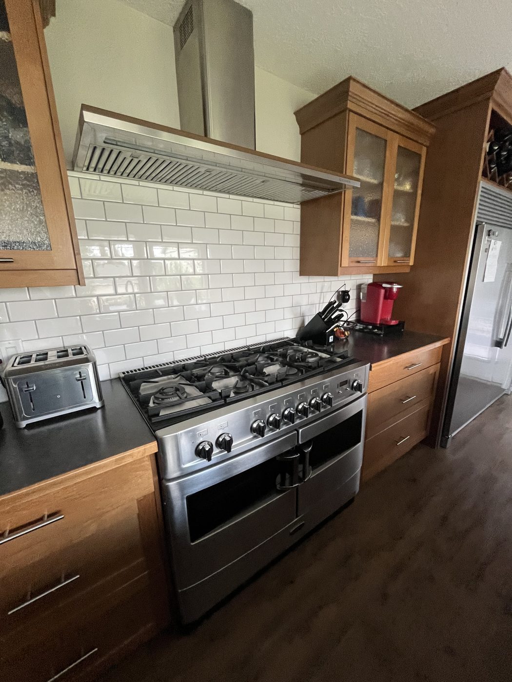 Clean kitchen with gleaming gas range and subway tile